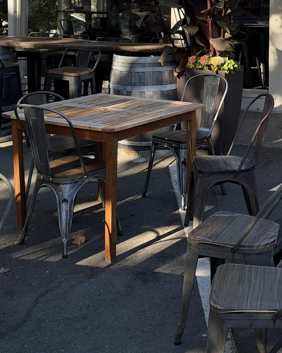 Wooden café tables, metal bistro chairs and a wine-barrel table on the Internos patio
